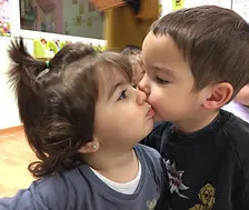 dos niños dándose un beso